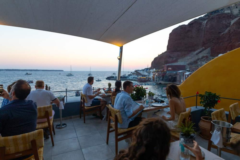 Romantic Sunset Restaurants in Santorini - How to Reserve the Best Romantic Sunset Restaurants in Santorini, Greece Terrace at the Sunset Ammoudi restaurant in Santorini, Greece.