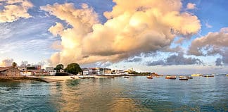 Most Popular Day Trips from Zanzibar Panorama of Stone Town on Zanzibar island in Tanzania during sunrise with dramatic clouds
