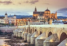 Visiting Cordoba: A Forgotten Giant of History Cordoba, Spain view of the Roman Bridge and Mosque-Cathedral on the Guadalquivir River.