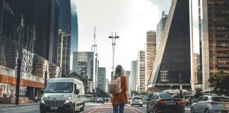 How to Choose the Right Travel Insurance: An Analytical Guide Walking in the middle of the Avenida Paulista, Brazil.
