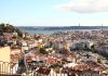 How to Understand Lisbon: A Smarter First Day for New Visitors Panoramic view of Lisbon, Portugal featuring colorful rooftops and the iconic Tagus River skyline.
