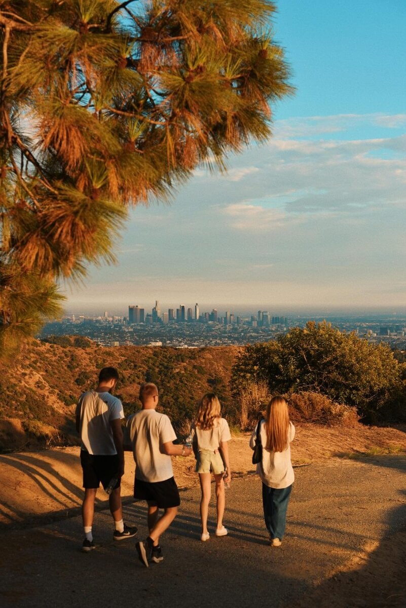 A group hiking in front of the scenic Los Angeles skyline. Pic via pexels - Katie-mukhina.