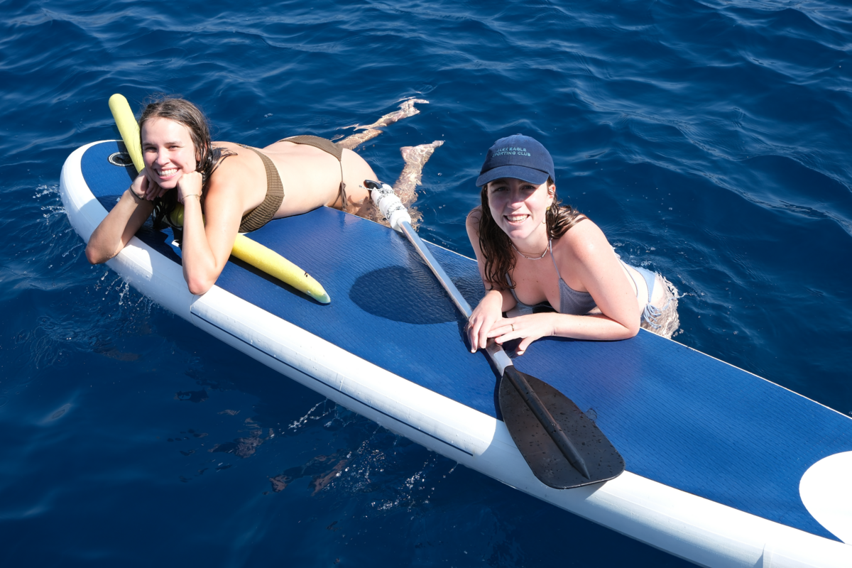 kekova blue cruise - Kekova Blue Cruise Guide: Cabin Charter vs Private Gulet Explained Guests enjoying a swim break during a cabin charter gulet cruise, relaxing on a paddleboard and spending time in the open sea.