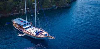 Kekova Blue Cruise Guide: Cabin Charter vs Private Gulet Explained Private gulet charter in Fethiye surrounded by pine forests and turquoise water.