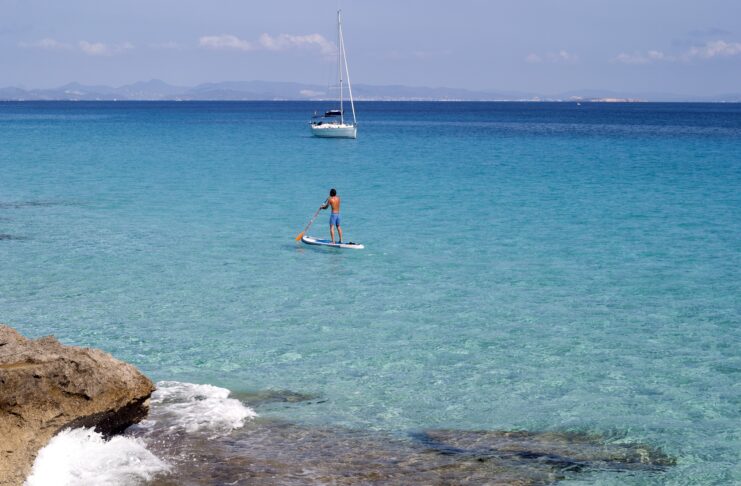 What to Do on a Day Trip or Short Stay in Formentera from Ibiza SUP and sailing yacht in Formentera, Spain.