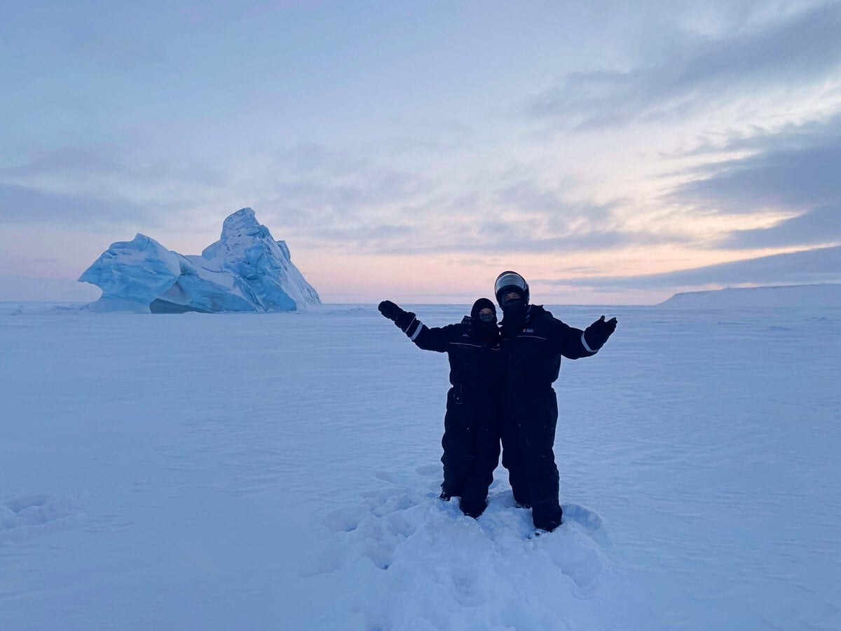 Eli and Jake from Penguin Trampoline Travel Blog in front of an Iceberg in Svalbard
