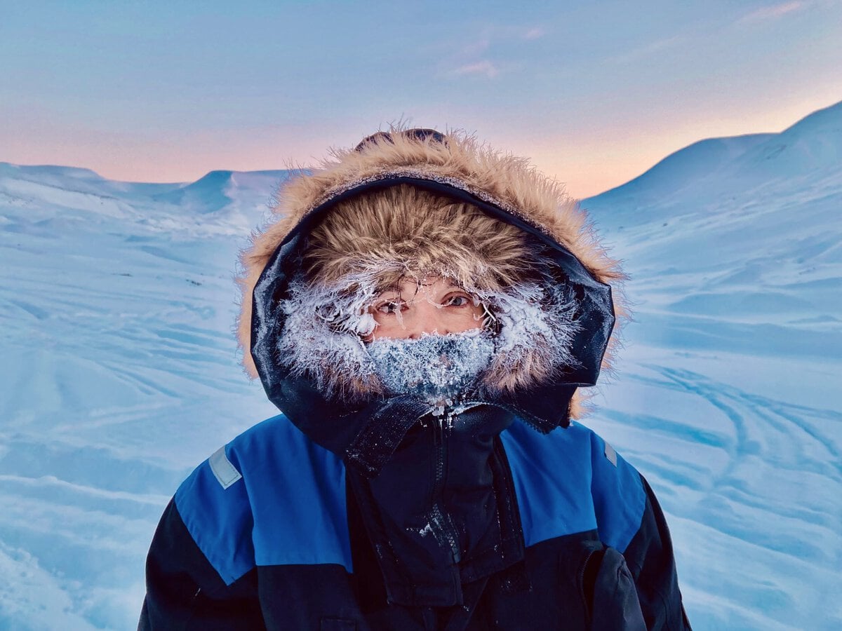 Woman with a frozen hoodie in Svalbard