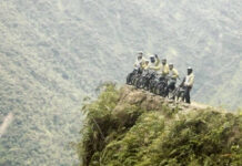 From Snow at La Cumbre to Jungle Heat: A Day on Bolivia’s Death Road group of riders on cliff edge of death road bolivia tour