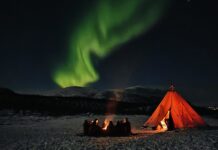 An Evening Walk With Huskies Northern Lights dancing above a traditional lávvu tent in Abisko, Swedish Lapland. Kopiera